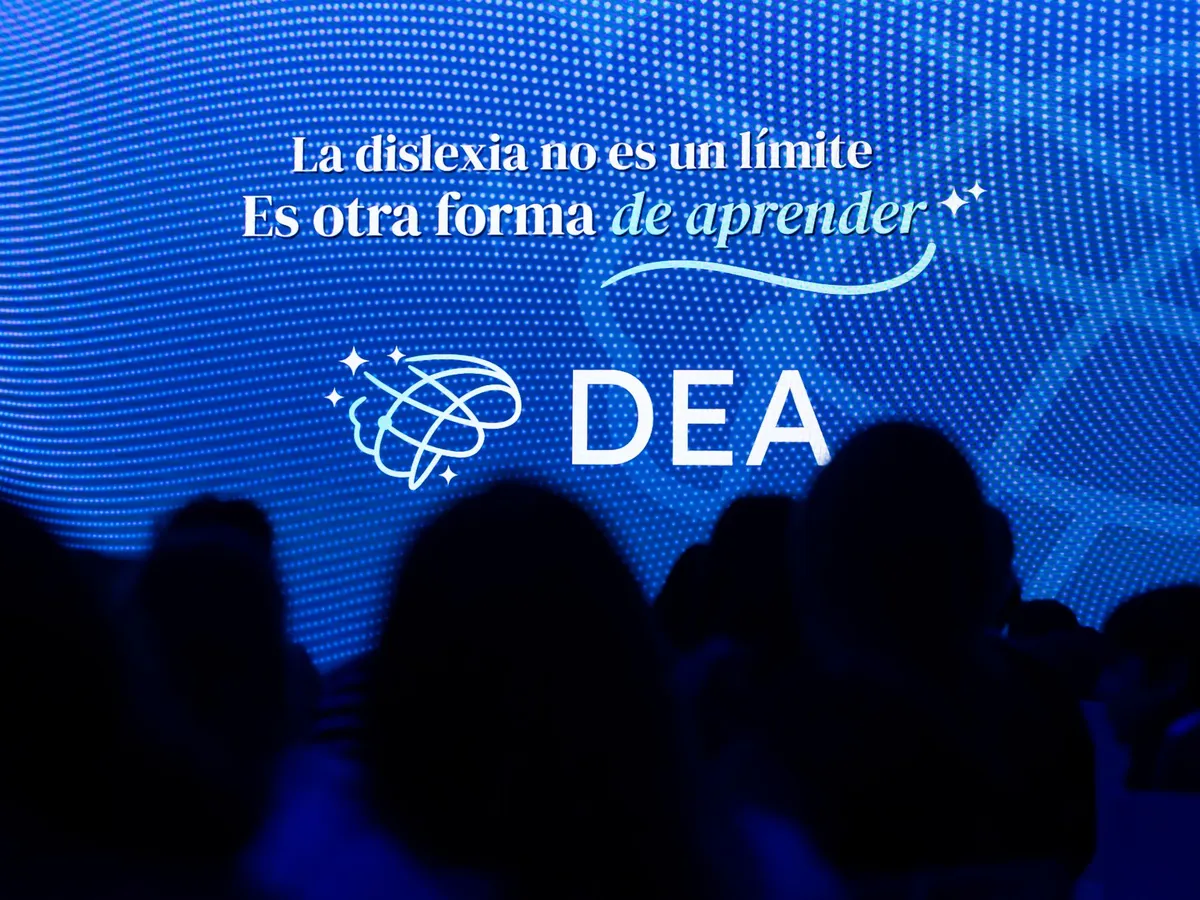Pantalla de un encuentro con el logo de DEA y la frase «La dislexia no es un límite. Es otra forma de aprender», con el público en primer plano