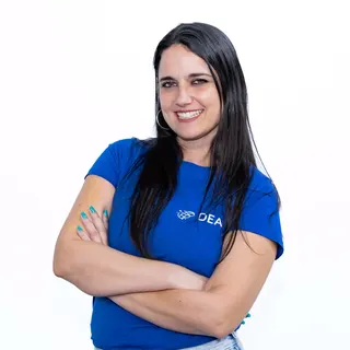 Angela Mateo, coordinadora pedagógica, sonriendo, con la camiseta de DEA